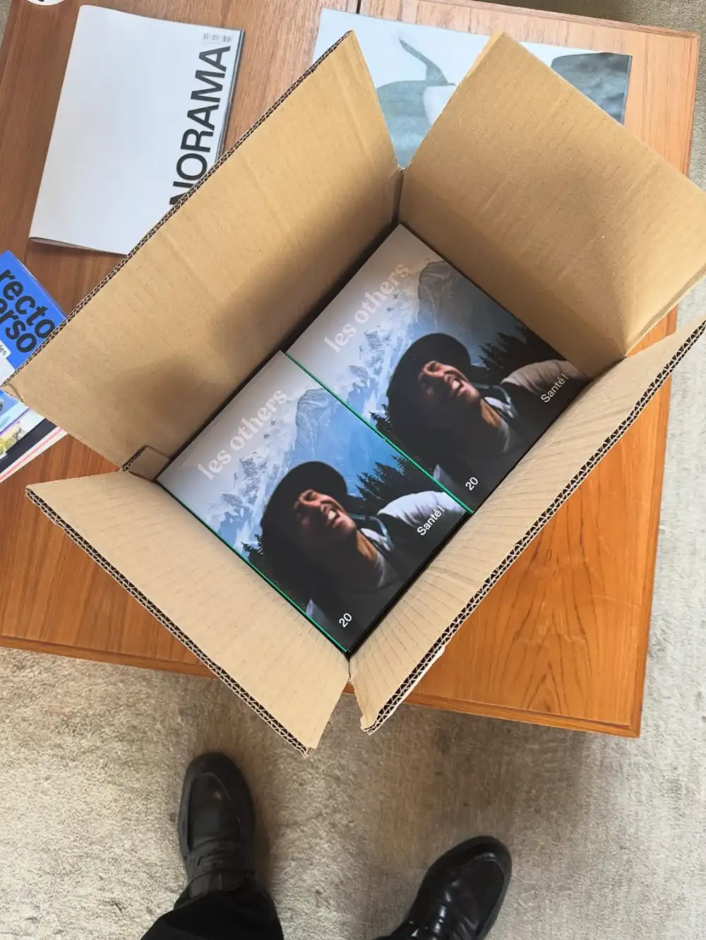 Un carton ouvert sur deux exemplaires du volume 20 des Others, « Santé ! »