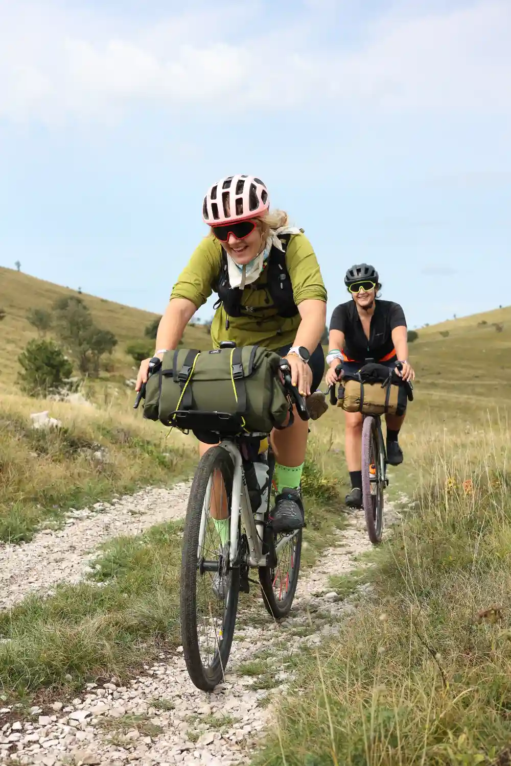 Deux cyclistes chargés de sacoches sur un chemin de terre